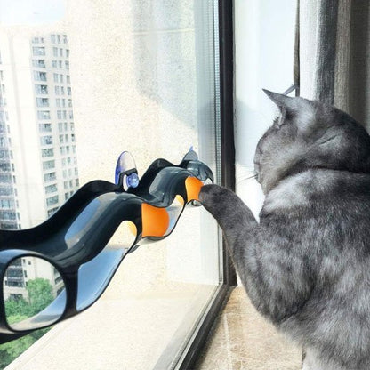 Chat gris qui joue avec son nouveau jouet interactif a balle orange