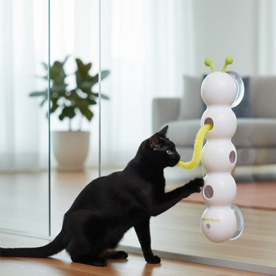 chat noir qui joue avec la ficelle jaune de son jouet chat interactif a ventouses