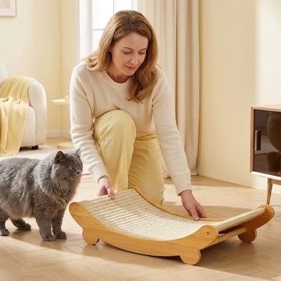 femme qui offre un nouveau griffoir chat en bois et sisal a son chat gris